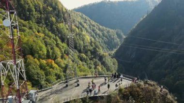 Romanya 'da doğanın insansız hava aracı görüntüsü. Karpat Dağları 'ndaki vadi Vidraru barajının yakınındaki insanlarla dolu, yemyeşil ormanlı yamaçlar.