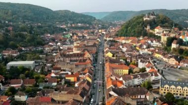 Romanya 'nın Sighisoara Tarih Merkezi' nin insansız hava aracı görüntüsü. Eski binalar, arabalı sokaklar, yeşillikler.