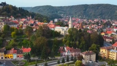 Romanya 'nın Sighisoara Tarih Merkezi' nin insansız hava aracı görüntüsü. Eski binalar, yeşilli sokaklar, arabalar.