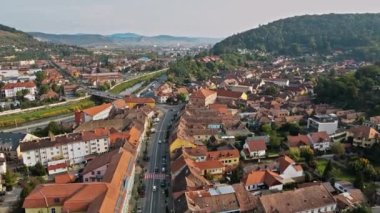 Romanya 'nın Sighisoara kentindeki hava aracı görüntüsü. Arabaları, nehri, yeşilliği ve binaları olan yollar