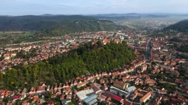 Romanya 'nın Sighisoara kentindeki hava aracı görüntüsü. Eski binalar, yeşillikler, arabalı yollar, tepeler