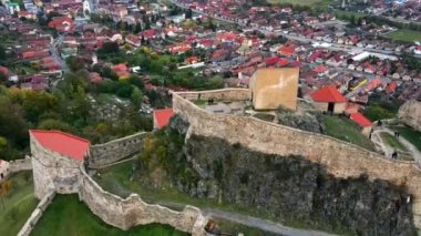 Romanya 'daki Rupea Kalesi' nin insansız hava aracı görüntüsü. Kale bir uçurumun kenarında, turistler, kasaba