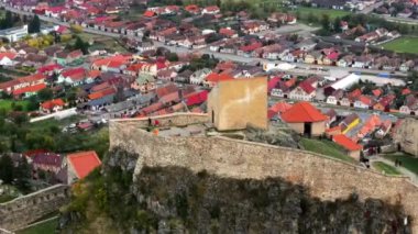 Romanya 'daki Rupea Kalesi' nin insansız hava aracı görüntüsü. Kale bir uçurumun kenarında, turistler, kasaba