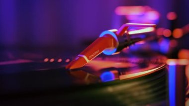 Dönen plak kaydı olan çalışan bir pikap. Neon mavi ve kırmızı aydınlatma