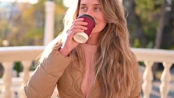 Γυναίκα Πίνει Καφέ Και Χαμογελάει Στο Πάρκο Ηλιοβασίλεμα — Αρχείο Βίντεο