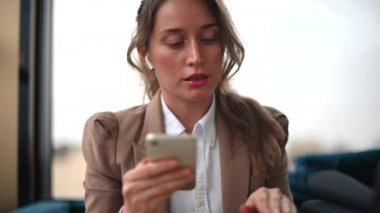 Pod kullanan bir kadın restoranda telefonla konuşuyor.