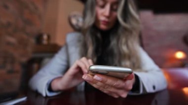 Yemekte restoranda cep telefonuyla çalışan bir kadın.