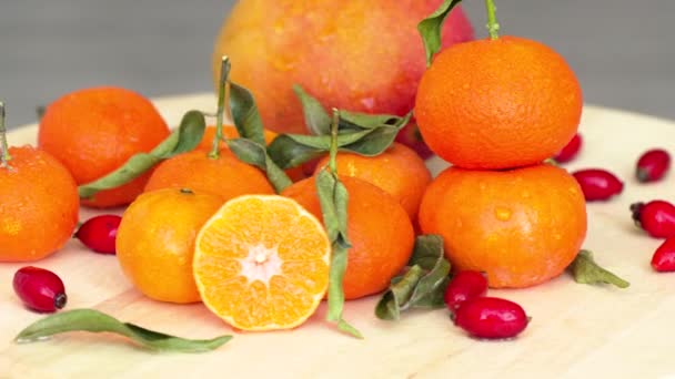 Komposition Mit Orangen Mango Hagebutten Und Grünen Blättern — Stockvideo