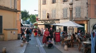ANTIBES, FRANCE - 30 AĞUSTOS 2021: Geleneksel binalar, yürüyen insanlar, kafeler
