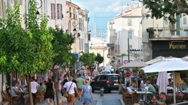 ANTIBES, FRANCE - 30 AĞUSTOS 2021: Geleneksel binalar, yürüyen insanlar, arabalar, yeşillik ve kafeler