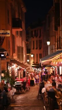 CANNES, FRANCE - 31 AĞUSTOS 2021: Birden fazla kafesi ve adamı olan yayalar. Dikey görünüm