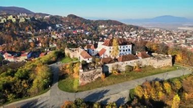 Romanya 'nın Brasov kentindeki Kale' nin hava aracı görüntüsü. Bir tepenin üstündeki ortaçağ kalesi. Binalar, sarı ağaçlar, turistler