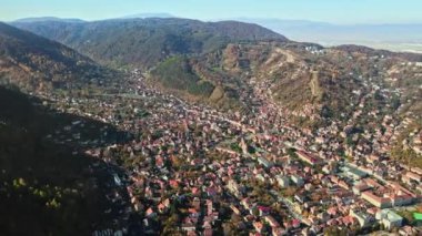 Romanya 'nın Brasov kentindeki hava aracı görüntüsü. Yerleşim yerleri, sarı ağaçlar, Karpatlar.