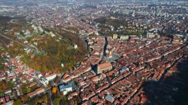 Romanya 'nın Brasov kentindeki hava aracı görüntüsü. Eski şehir merkezi, konut binaları, sarı ağaçlar.