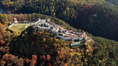 Romanya 'daki Rasnov Kalesi' nin insansız hava aracı görüntüsü. Tepenin tepesinde Rasnov yazıtı olan ortaçağ kalesi, Karpatlar