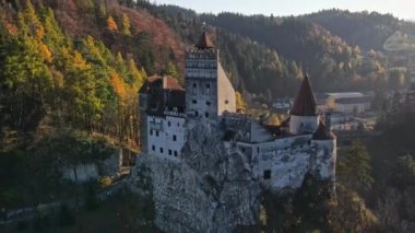 Romanya 'daki Bran Kalesi' nin insansız hava aracı görüntüsü. Karpatlar 'daki ortaçağ şatosu, sararmış ağaçlar, turistler