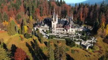 Romanya 'daki Peles Kalesi' nin insansız hava aracı görüntüsü. Karpatlar 'da bahçeli bir kale, etrafında orman, turistler.