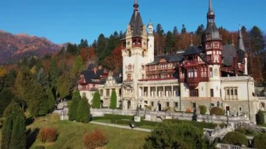 Romanya 'daki Peles Kalesi' nin insansız hava aracı görüntüsü. Karpatlar 'da bahçeli bir kale, etrafında orman, turistler.