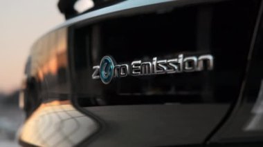 CHISINAU, MOLDOVA - 12 Kasım 2021: Elektrik Nissan Yaprak Sıfır emisyon yazısı, dikiz açısı, günbatımı