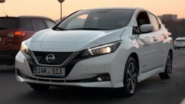 CHISINAU, MOLDOVA - 12 Kasım 2021: Gün batımında park halindeki beyaz Nissan Yaprağı 'nın dışı,
