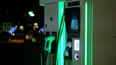Geceleri yeşil ışıklı elektrikli araba şarj noktası makinesi