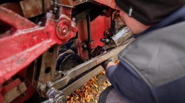 VISEU DE SUS, ROMANIA - 29 Ekim 2021: Bir tren istasyonunda durdurulan Mocanita buharlı treninin mekanizmalarına yağ ekleyen tamirci. Yavaş çekim