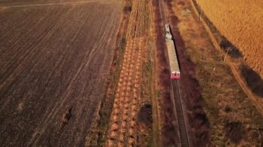 Sonbaharda Moldova 'da hareket halindeki bir trenin hava aracı görüntüsü. Sarı bitki örtüsü, yavaş çekim