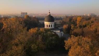 Chisinau 'nun sonbaharda gün batımında Moldova' da hava aracı görüntüsü. Sarı ağaçlar ve insanlar ile Central Park, Katedral, yavaş çekim