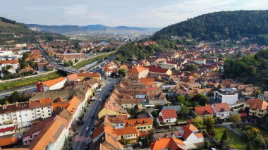 Romanya 'nın Sighisoara Tarih Merkezi' nin insansız hava aracı görüntüsü. Eski binalar, yeşil sokaklar, arabalar, nehir, tepeler