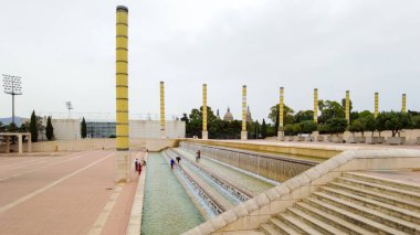 Estadi Olimpik Lluis Şirketleri, önünde çocuklarla oynayan kare ve çeşme.