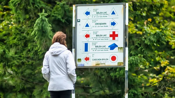 Uma Mulher Olhando Para Sinal Guia Balea Resort Romênia Verdura — Fotografia de Stock