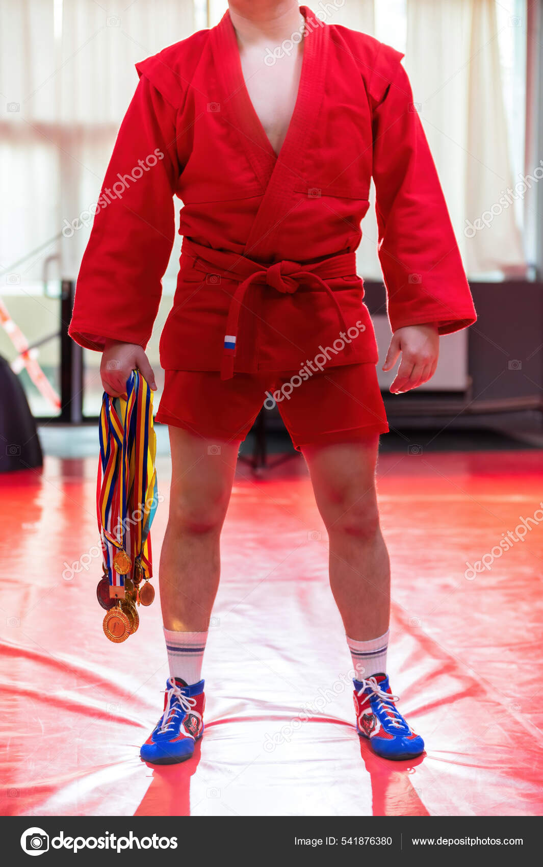 Боец Самбо Красном Кимоно Позирует Держит Руках Кучу Медалей.