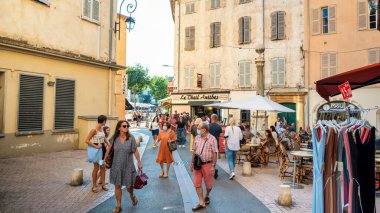 ANTIBES, FRANCE - 30 AĞUSTOS 2021: Geleneksel binalar, insanlar, yeşillik ve kafeler