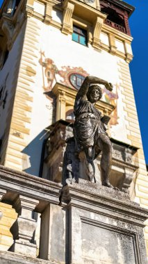 Romanya 'daki The Peles Castle' daki heykelin dikey görüntüsü. Arka planda Castle