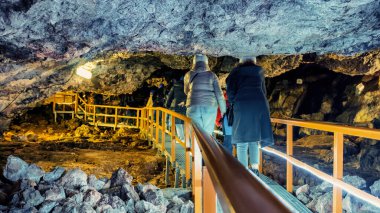 Romanya 'nın Bucegi Dağları' ndaki Ialomitei Mağarası manzarası. Turistler, köprüler, aydınlanma