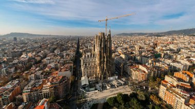 İspanya, Barcelona 'daki Sagrada Familia' nın hava aracı panoramik görüntüsü. Etrafında birden fazla bina ve yeşillik olan bloklar.