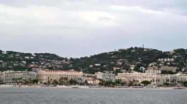 Fransa 'da yüzen bir tekneden Cannes manzarası. Geleneksel stil, yeşillik ve plajda yapılmış çok sayıda bina.