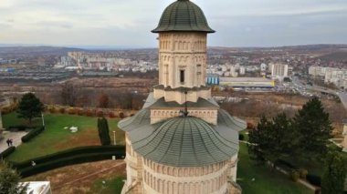 Romanya 'nın Iasi kentindeki Cetatuia Manastırı' nın insansız hava aracı görüntüsü. Ana kilise, iç saray ve binalar antik duvarlarla çevrili, arka planda şehir.
