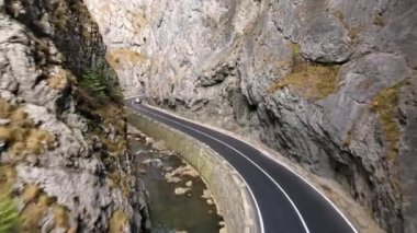Romanya 'da doğanın insansız hava aracı görüntüsü. Karpat Dağları, Vadide arabalı yollar, Kayalık kayalıklar, nehir