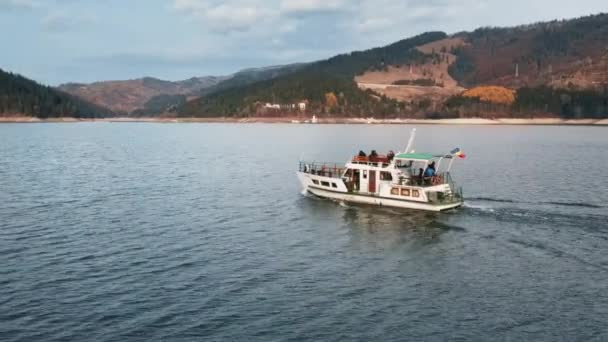 在罗马尼亚的Bicaz湖上 一架载有乘客的船被无人驾驶飞机拍到 覆盖着茂密森林的小山 — 图库视频影像