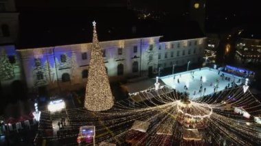 Romanya 'nın Sibiu kentindeki Büyük Meydan' ın insansız hava aracı görüntüsü. Noel için dekore edilmiş eski şehir merkezi. Buz pateni pisti, eski geleneksel binalar, insanlar