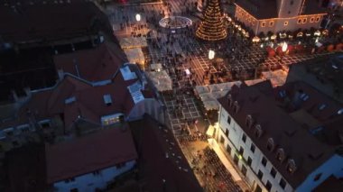 Romanya 'nın Brasov kentindeki Konsey Meydanı' nın hava aracı görüntüsü. Noel için dekore edilmiş eski şehir merkezi. İlçe Tarih Müzesi, binalar, insanlar