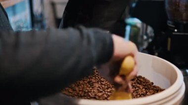BRASOV, ROMANIA - 2021 ARALIK: Bir kahve dükkanında bir poşet kahveyi dolduran barista