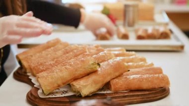 Bir kadın güzel bir şekilde tabağın üzerine hazır plaketler seriyor.