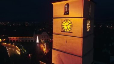 Romanya 'nın Sibiu kentindeki Büyük Meydan' ın insansız hava aracı görüntüsü. Noel için dekore edilmiş eski şehir merkezi. Dönme dolap, buz pateni pisti, çan kulesi, insanlar