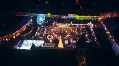 Romanya 'nın Sibiu kentindeki Büyük Meydan' ın insansız hava aracı görüntüsü. Noel için dekore edilmiş eski şehir merkezi. Dönme dolap, buz pateni pisti, millet