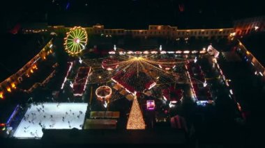 Romanya 'nın Sibiu kentindeki Büyük Meydan' ın insansız hava aracı görüntüsü. Noel için dekore edilmiş eski şehir merkezi. Dönme dolap, buz pateni pisti, millet
