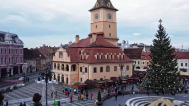 BRASOV, ROMANIA - Aralık 2021: Romanya 'nın Brasov kentindeki Konsey Meydanı' nın insansız hava aracı görüntüsü. Noel için dekore edilmiş eski şehir merkezi. İlçe Tarih Müzesi, binalar, insanlar