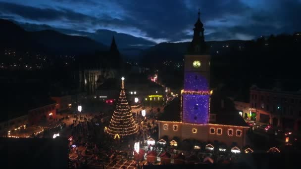 ルーマニアの夜にブラソフの評議会広場の空中ドローンビュー クリスマスのために装飾された旧市街中心部 郡歴史博物館 — ストック動画