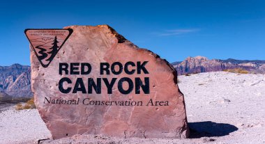 Red Rock Kanyonu tabelası, arka planda Nevada, ABD 'deki uçurumlar.